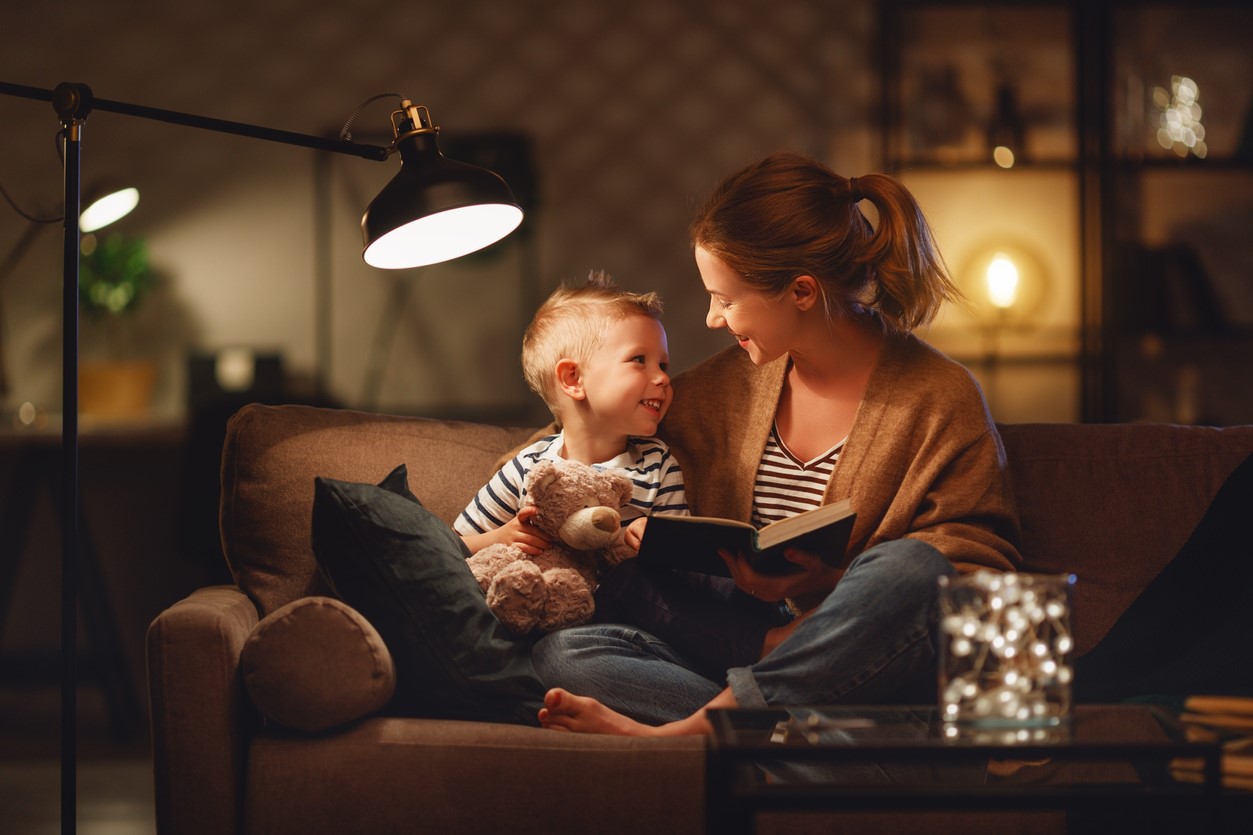 Mother and child reading by lamplight